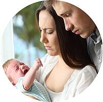 Eltern schauen besorgt auf ihr schreiendes Baby